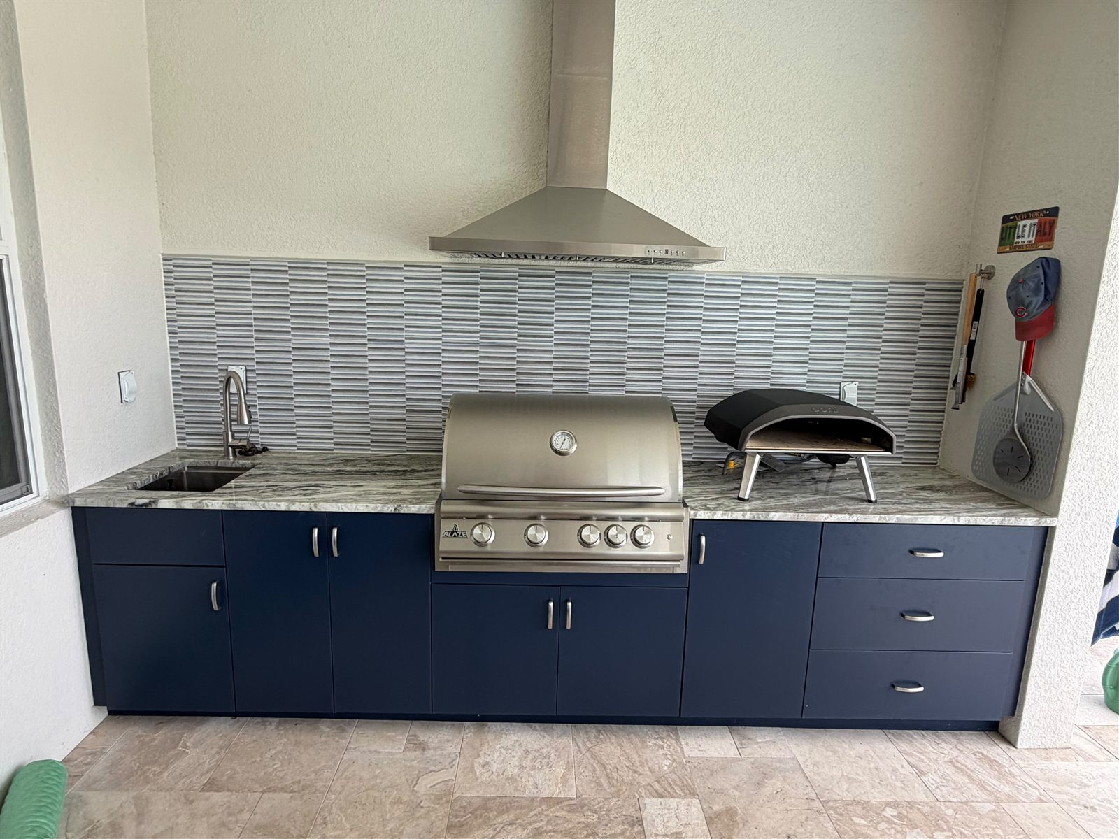 Navy line outdoor kitchen with marble backsplash
